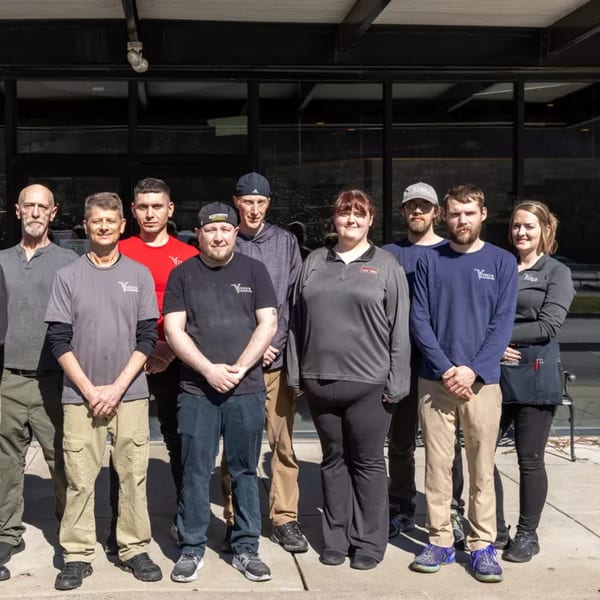 Nine Vito's Coal Fired Pizza & Restaurant staff members stand outside the restaurant.